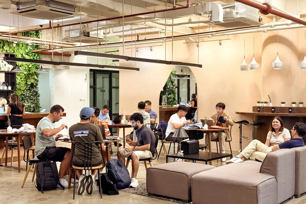 The busy lounge at Acceler8 Legazpi, members working across sofas and shared tables