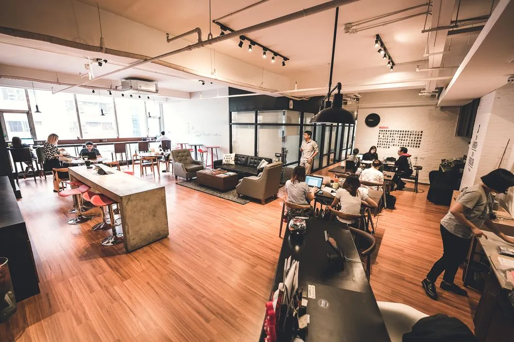The coworking floor at Acceler8 Salcedo, warm timber and long shared tables