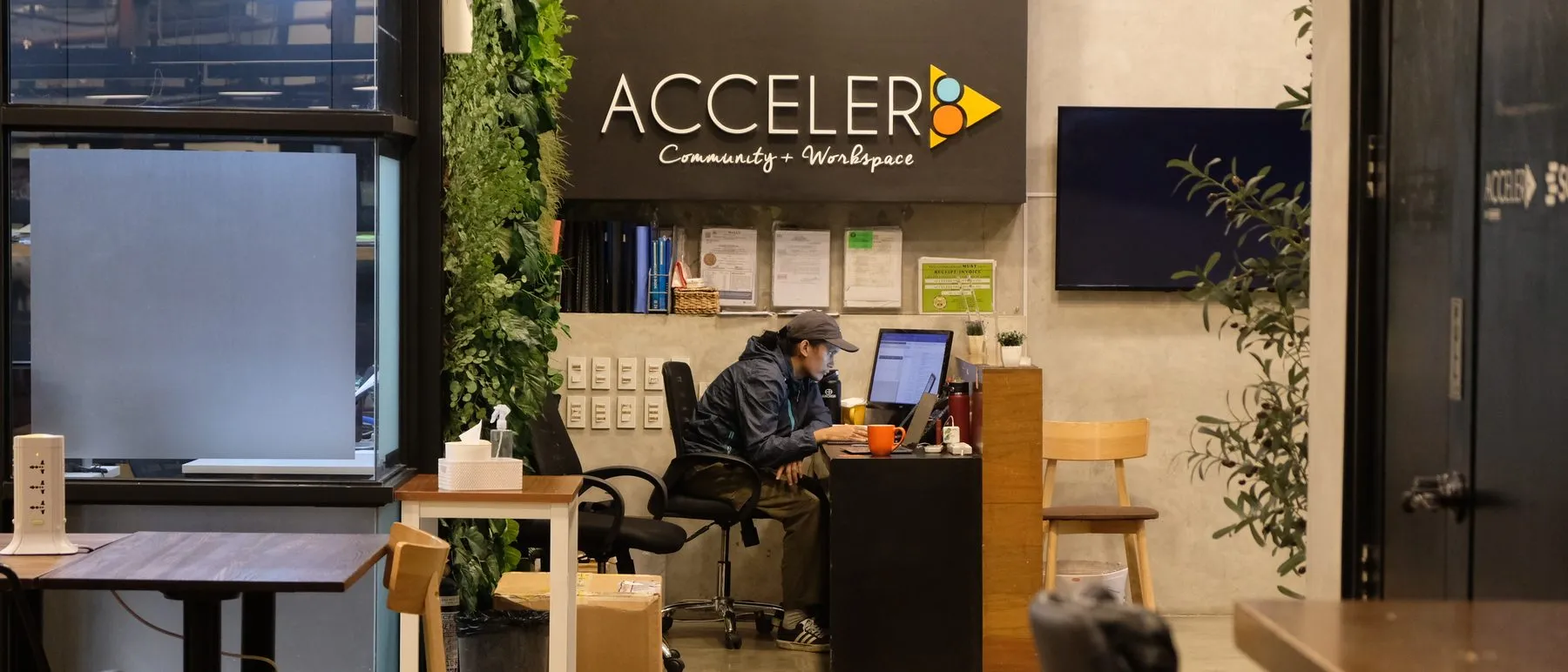 The Acceler8 front desk, staffed, beside the living green wall