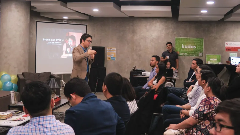 A speaker presenting to a seated audience at an Acceler8 Legazpi event